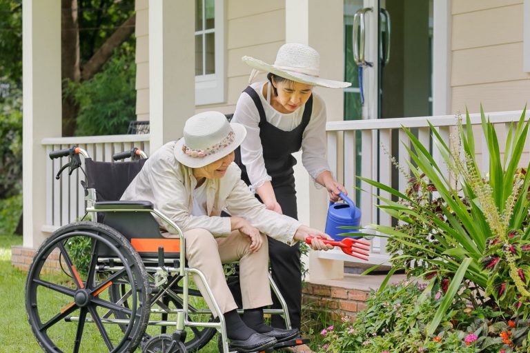 Elderly woman gardening in backyard with daughter