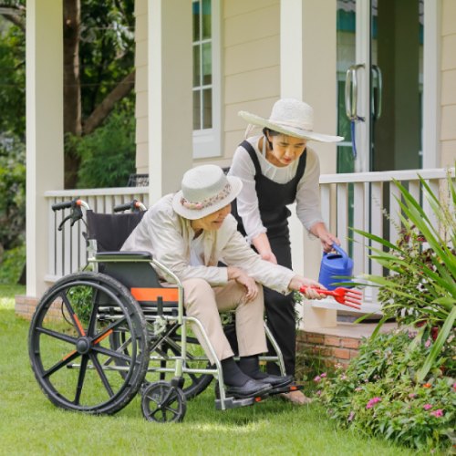 Caregiver with an old lady watering plant