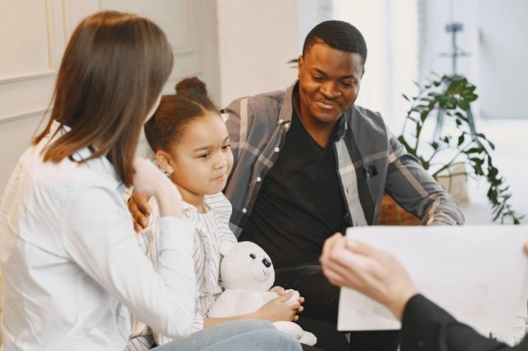 ABA-therapy-eqc Kid having therapy while sitting with her parents around