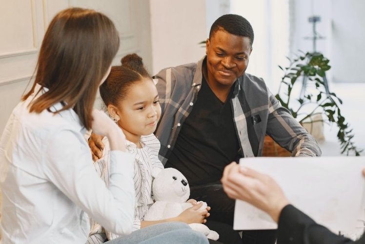 ABA-therapy-eqc Kid having therapy while sitting with her parents around