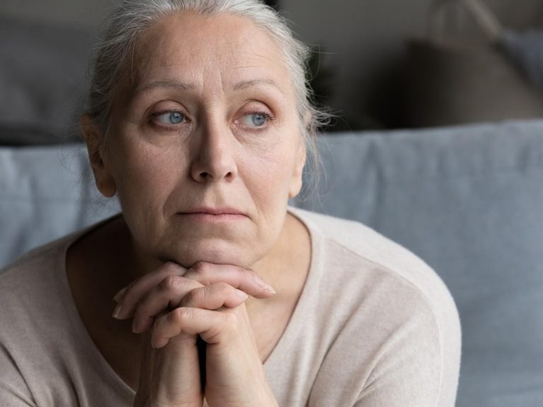 Old lady looking out while in deep thoughts