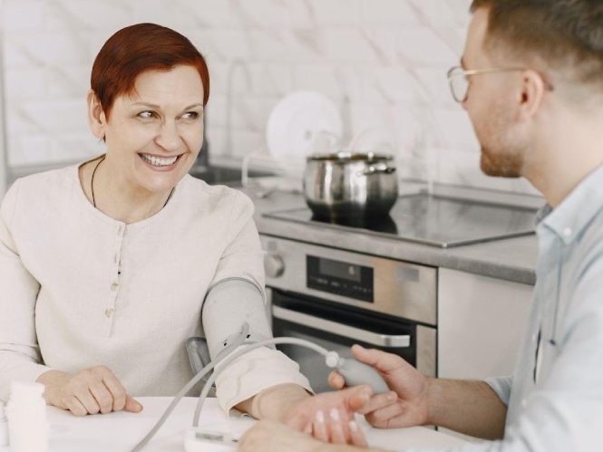 lady smiling at the doctors while getting checked at home
