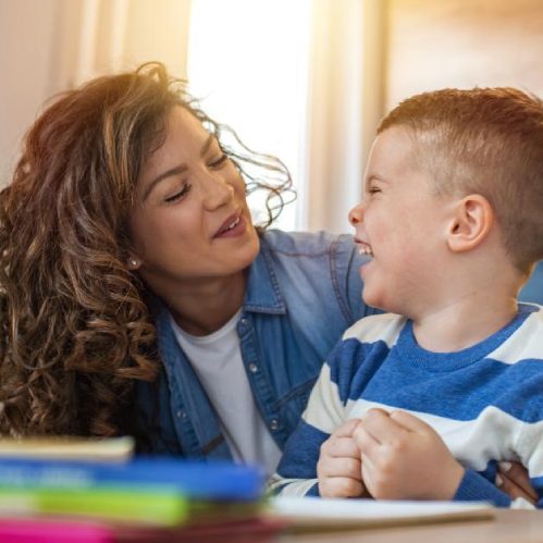 A young woman making a young boy laugh