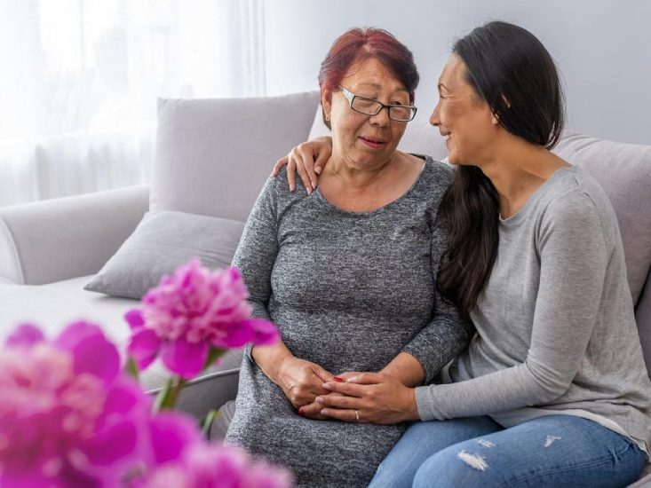 A young caregiver supporting an old lady to feel good