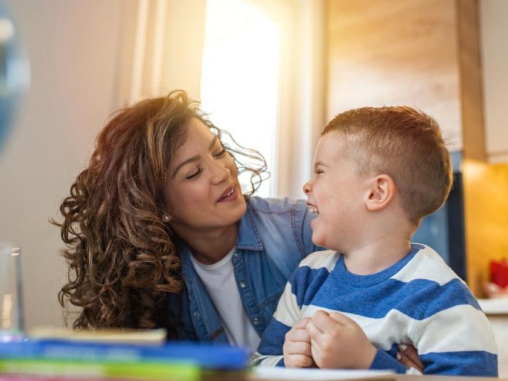 A young woman making a young boy laugh