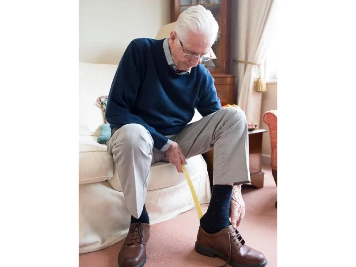 Old man wearing his shoes by himself