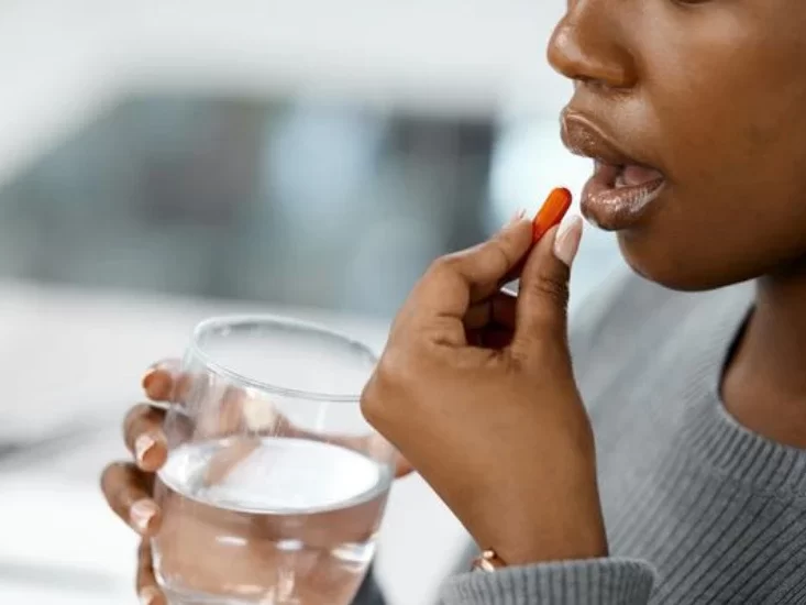 Young woman taking medicine