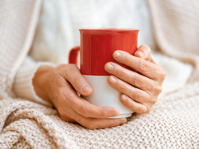 A senior lady holding a cup in a warm weather