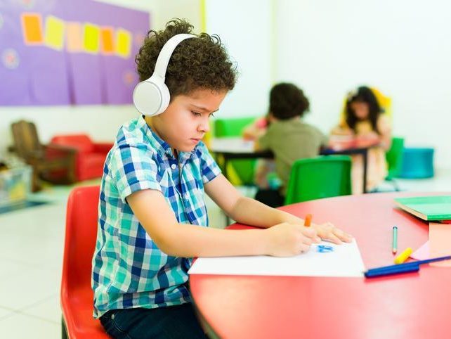 Child colouring with his headphones on