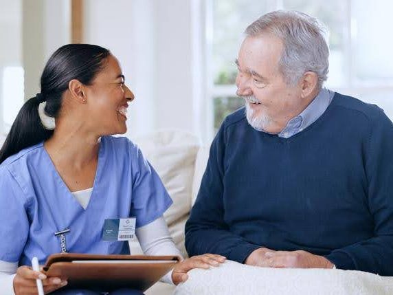 old man and eqc home care nurse having a good laugh