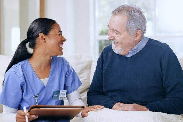 In-Home Care Consultation old man and eqc home care nurse having a good laugh