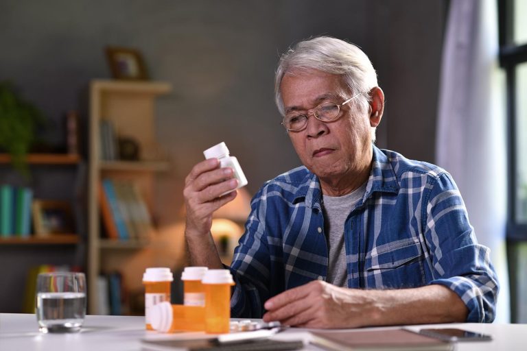 medication expert Old man looking at the details written on medicine bottle