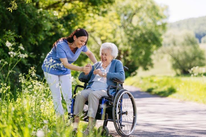 Nurturing Mental Health and Well-being EQC caregiver making an old woman on a wheelchair laugh